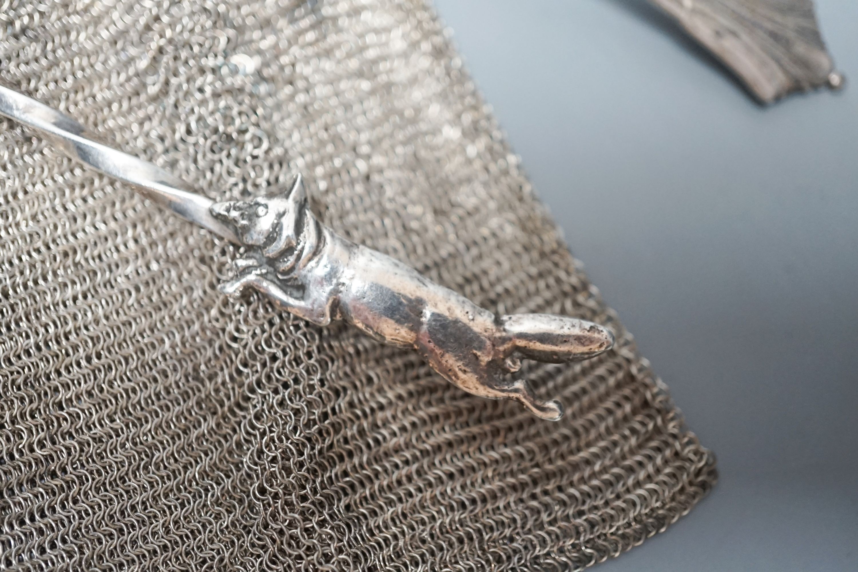 A George silver Arts & Crafts spoon, by Albert Edward Jones, two white metal mesh evening bags and a silver sparrow pourer spoon.